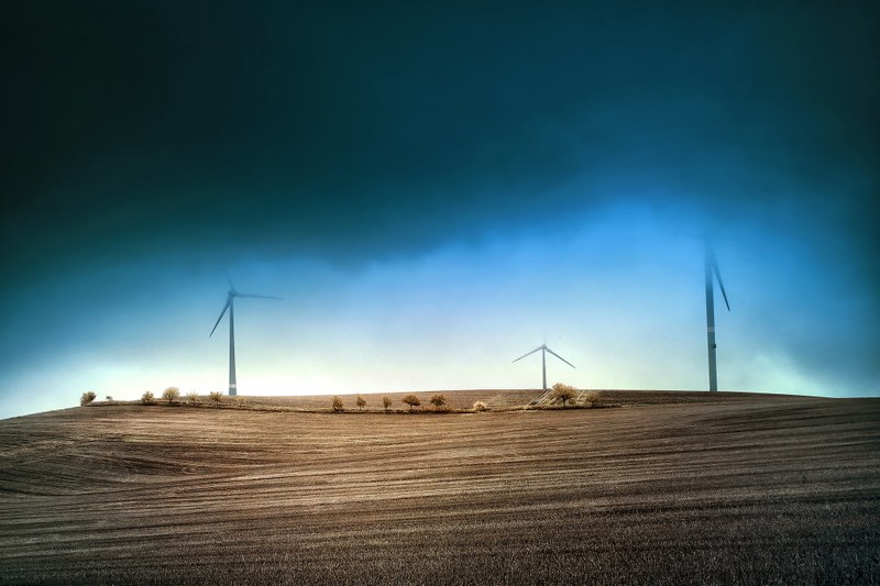 Wind turbines in the horizon against stormy skies