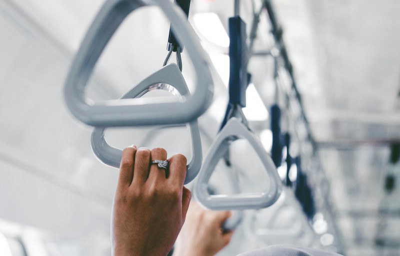 A person holding onto a metal object on a train